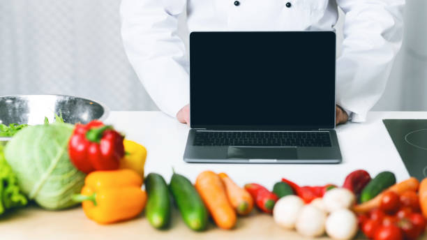 Unrecognizable Chef Man Showing Laptop Screen Standing In Kitchen, Mockup