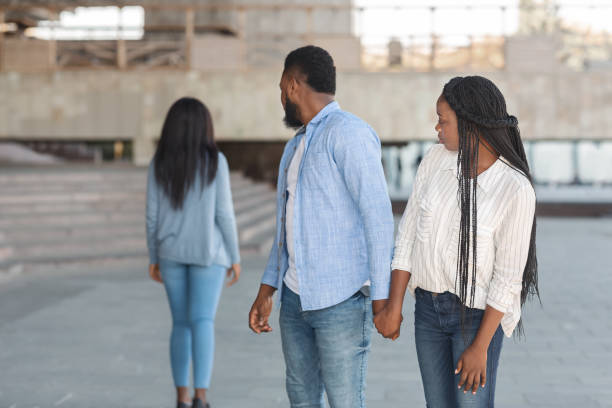 istock Afro man distracted to another woman while walking with his girlfriend 1198237595