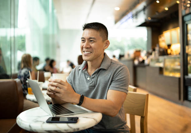 istock Man using laptop and smart phone in cafe 1198238647