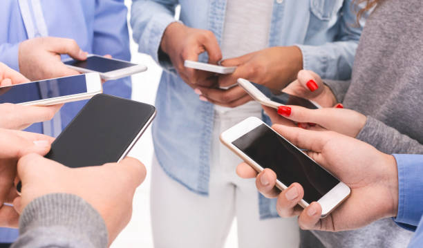 istock Group of millennials using cellphones, standing in circle 1198238865