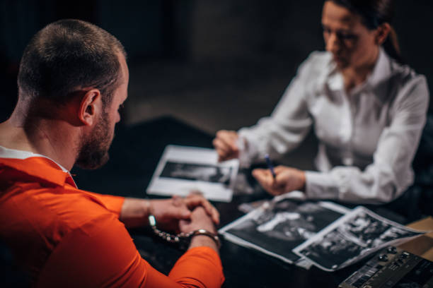 istock Woman detective interrogating a man prisoner in interrogation room 1198239285