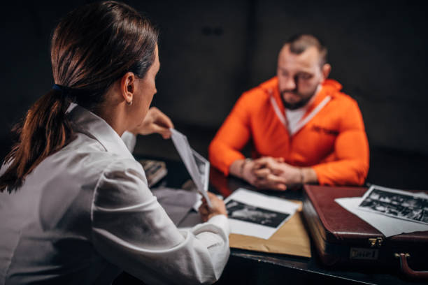 istock Woman detective interrogating a man prisoner in interrogation room 1198239332