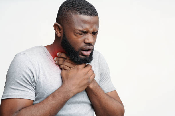 istock Unhealthy black guy touching neck and coughing 1198240019