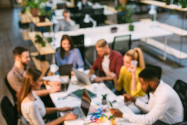 Team of designers working with laptops in office, blurred image