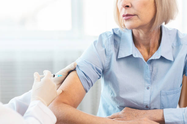 Closeup nurse doing vaccination to senior woman Healthcare Concept. Cropped image of unrecognizable nurse giving injection to mature woman, free space tetanus photos stock pictures, royalty-free photos & images
