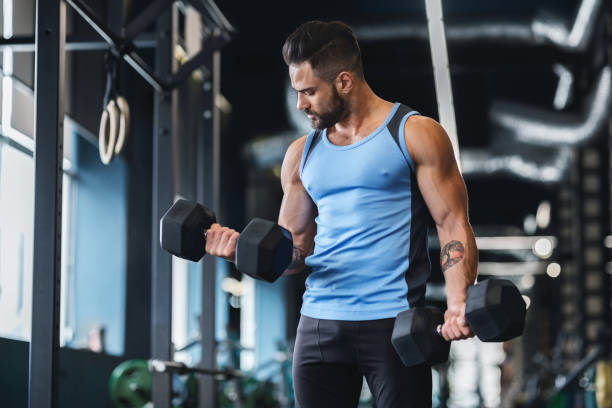 istock Strong muscular man doing exercises with dumbbells 1198242136
