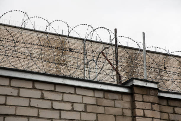 istock Prison or protected area. High brick walls with barbed wire. 1198244270