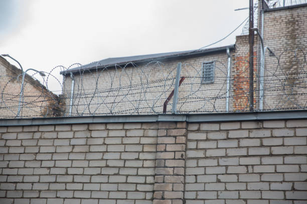 istock Prison or protected area. High brick walls with barbed wire. 1198244278