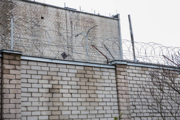 istock Prison or protected area. High brick walls with barbed wire. 1198244297