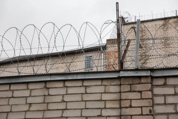 istock Prison or protected area. High brick walls with barbed wire. 1198244303