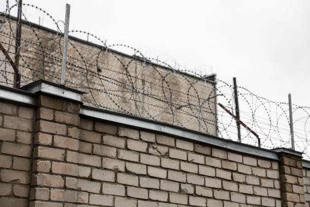 istock Prison or protected area. High brick walls with barbed wire. 1198244335