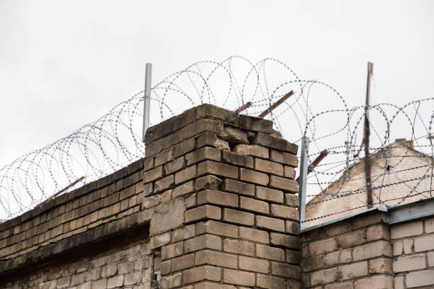 istock Prison or protected area. High brick walls with barbed wire. 1198244339