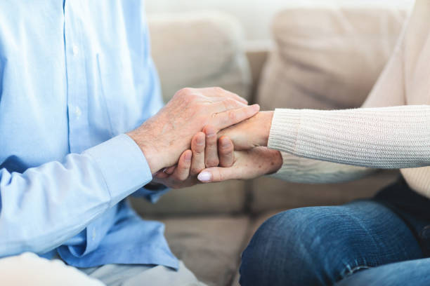istock Happy elderly couple holding hands at home 1198244719