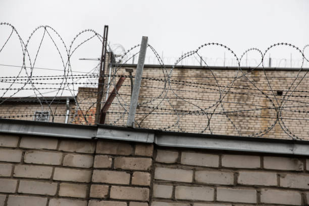 istock Prison or protected area. High brick walls with barbed wire. 1198244744