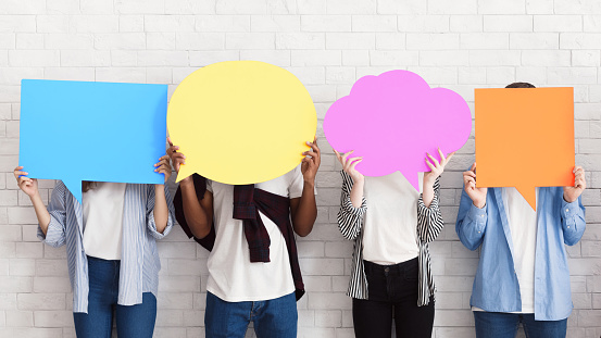 Sharing ideas. Teens holding empty colourful speech bubbles with free space