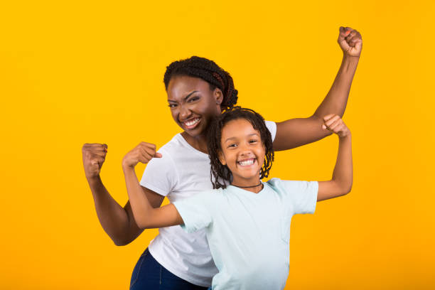 funky donna afroamericana e ragazza alzando i pugni - child celebration cheering victory foto e immagini stock