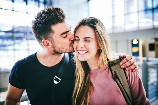 Cropped shot of a happy young couple standing together at the airport