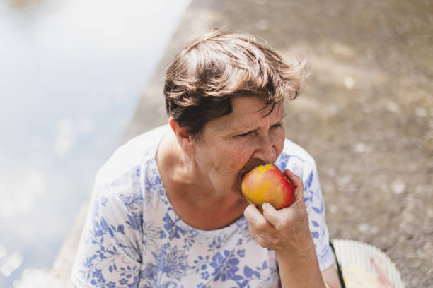 istock Retired elderly woman biting from an apple 1198247542