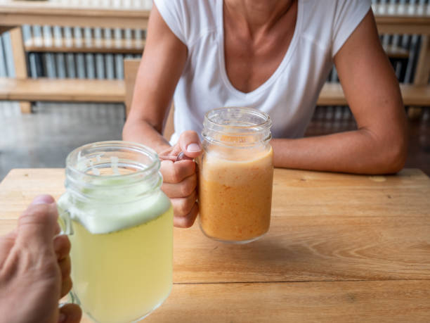 istock Two people in cafe sharing smoothie drinks together 1198247579