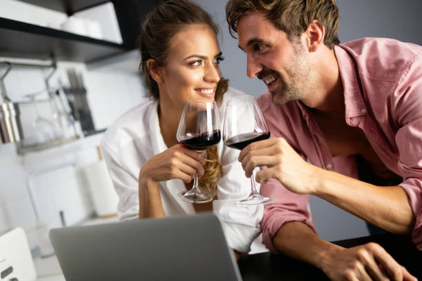 feliz pareja sonriente usando portátil en casa - drinking little girls women wine fotografías e imágenes de stock