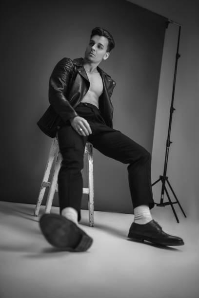 istock Elegant casual man model posing on black background on chair 1198249716