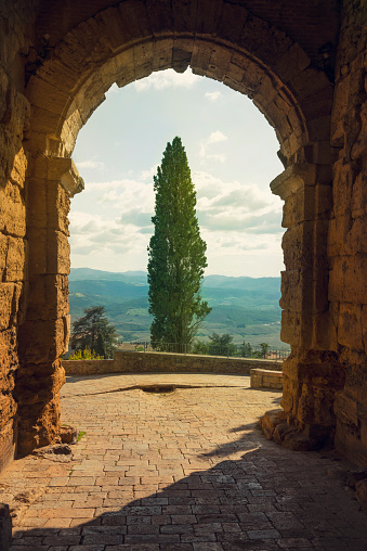 Scenic Tuscany landscape framed with a stone archway