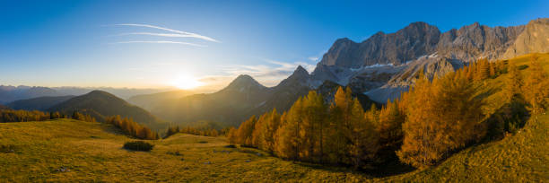 peaceful panoramic aerial view at sunset high up in alpine mountain landscape on sunny autumn day
