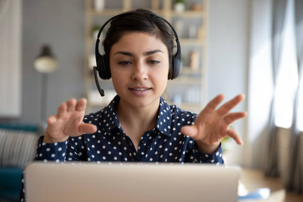 indian woman teacher wear wireless headset video calling on laptop - cyberspace support computer assistance imagens e fotografias de stock