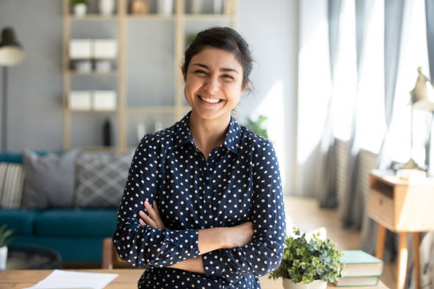 Smiling indian woman looking at camera posing at modern home