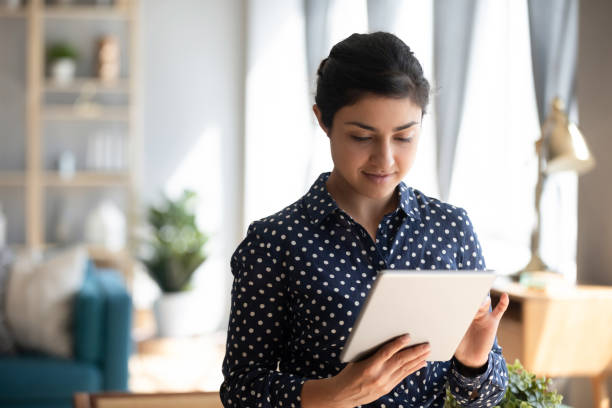 Young indian girl using digital tablet stand at home office