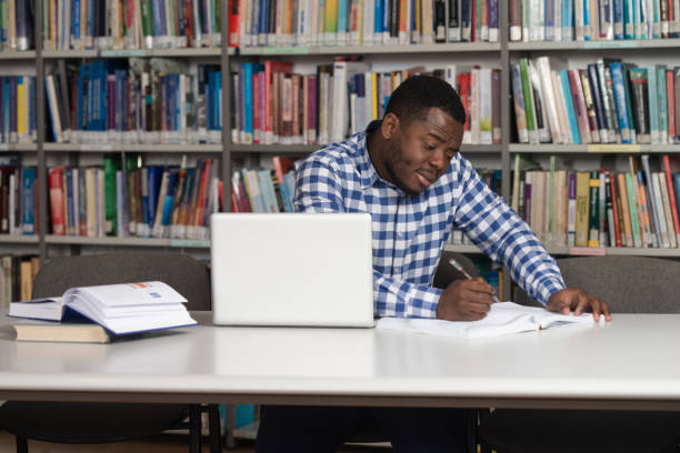 istock Happy African Male Student With Laptop In Library 1198254131
