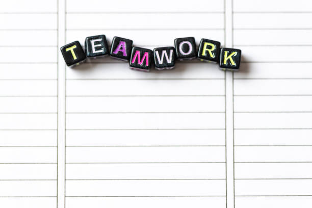 istock Teamwork word from blocks on clean page notebook close up. 1198255977