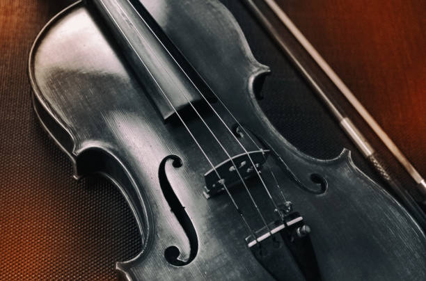 istock The abstract art design background of violin front sde,put beside blurred bow,on black canvas,blurry light around 1198258027