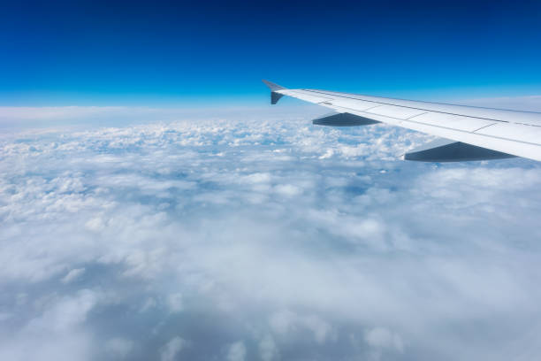 Airplane Wing in Flight from window, cloudy sky Airplane Wing in Flight from window, cloudy sky airplane ticket photos stock pictures, royalty-free photos & images