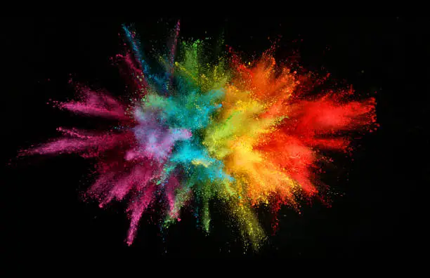 Photo of Explosion of colored powder isolated on black background