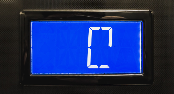 broken blue LCD display showing 0 in an elevator