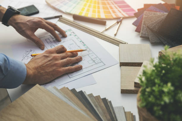 istock interior designer working with house plan blueprints in office 1198261864