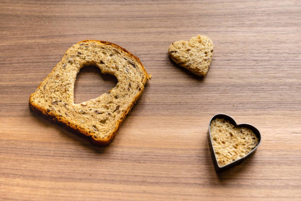 istock Bread with heart-shaped cut and heart from bread. Wooden texture background. 1198263142
