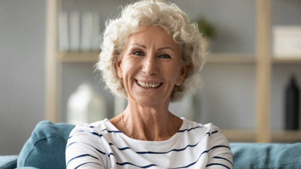 istock Headshot portrait elderly woman resting on couch looking at camera 1198265970