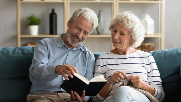 istock Husband reading book wife knitting seated on couch 1198266016
