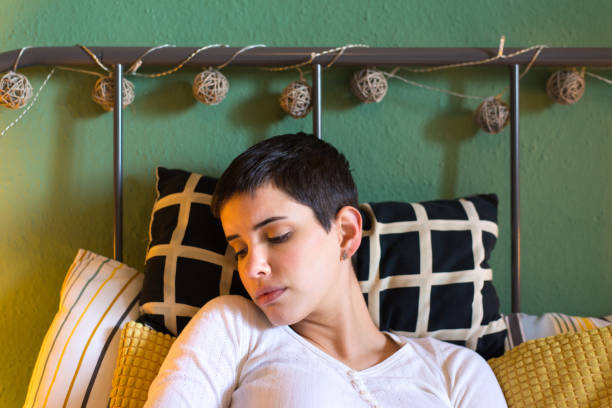 istock Sad young woman lying in the bed 1198268163