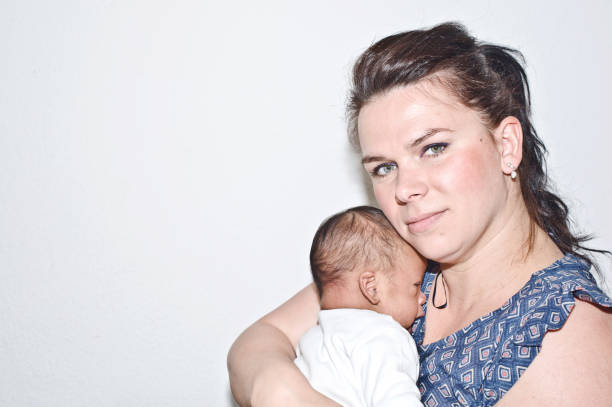 мать обнимает новорожденного ребенка - mother baby new kissing стоковые фото и изображения