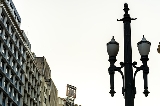2019, december; Sao Paulo, Brazil. Old vintage street lamp, symbol of the downtown of the city, with some buildings.