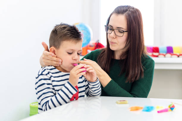 istock Children speech therapy concept. Preschooler practicing correct pronunciation with a female speech therapist. 1198270380