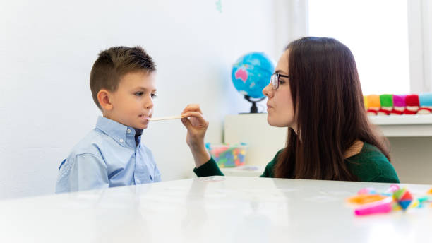 istock Children speech therapy concept. Preschooler practicing correct pronunciation with a female speech therapist. 1198270462