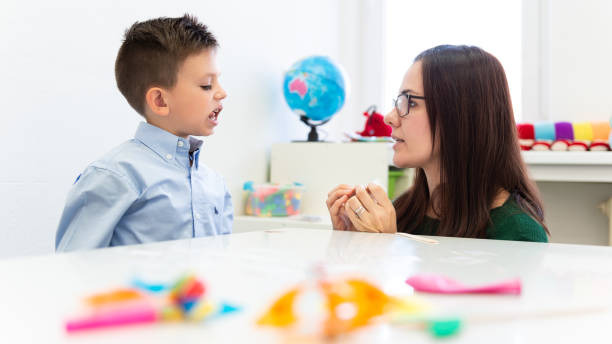 istock Children speech therapy concept. Preschooler practicing correct pronunciation with a female speech therapist. 1198270638