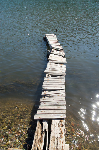 Small empty old  wooden pier in river in sunny day