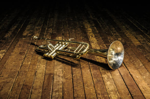 weiße messingtrompete liegt auf einer holzbühne - trumpet musical instrument music brass stock-fotos und bilder