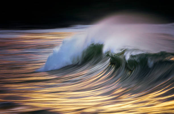 istock Photo of a wave breaking at sunset with in camera panning technique 1198273613