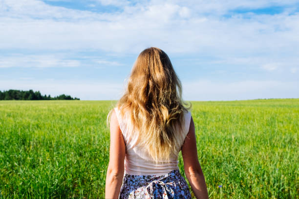 istock Young woman on a wheat field with sunlight 1198273784